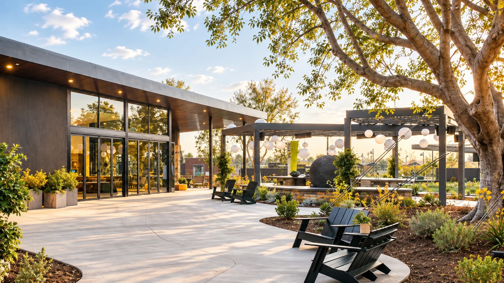 Beacon Park’s outdoor chairs, mature tree, and modern pavilion in afternoon light